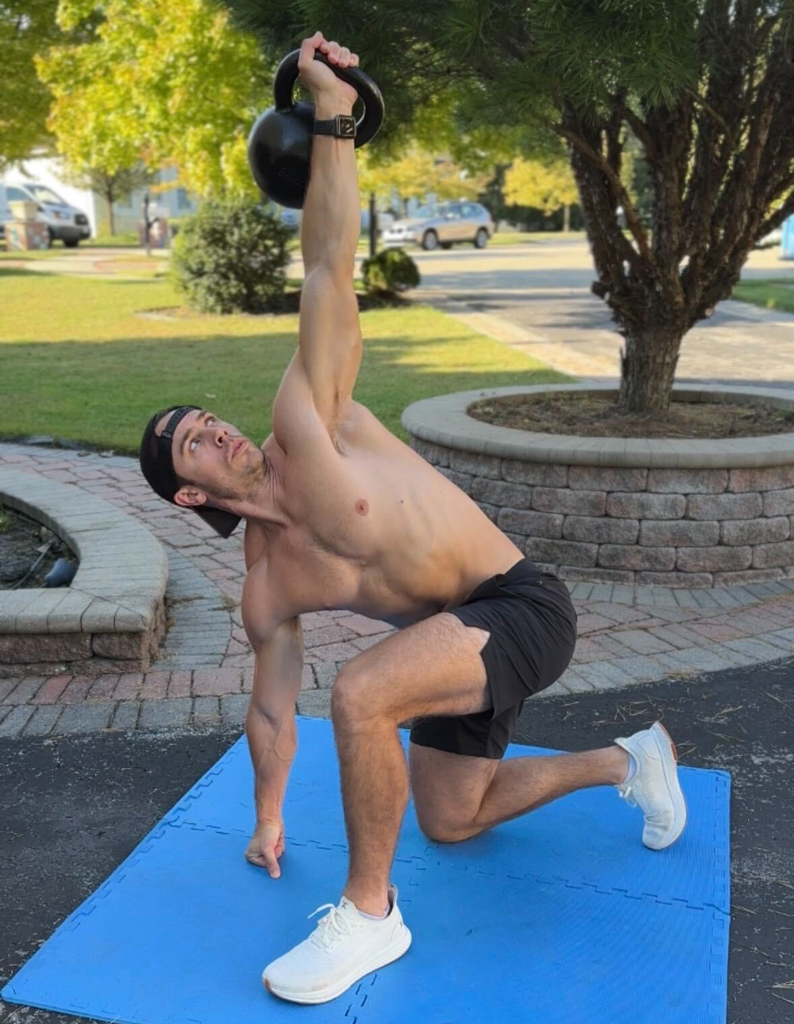 The coach is posing with kettlebell.